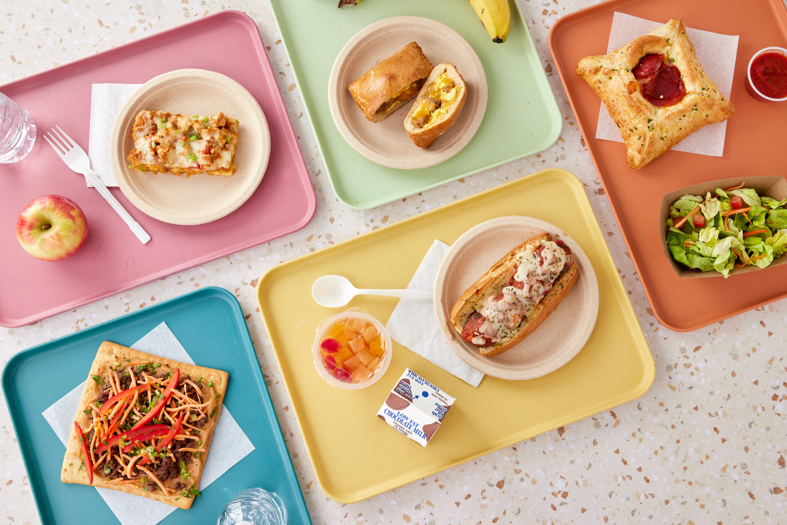 Colorful lunch trays with food.